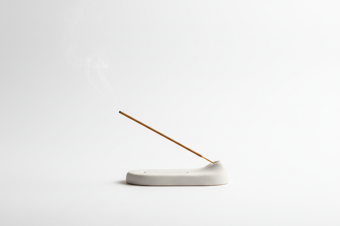 A lit coreless incense stick resting on a ceramic holder, soft smoke rising, zen home aesthetic by STILL ATARAXIA